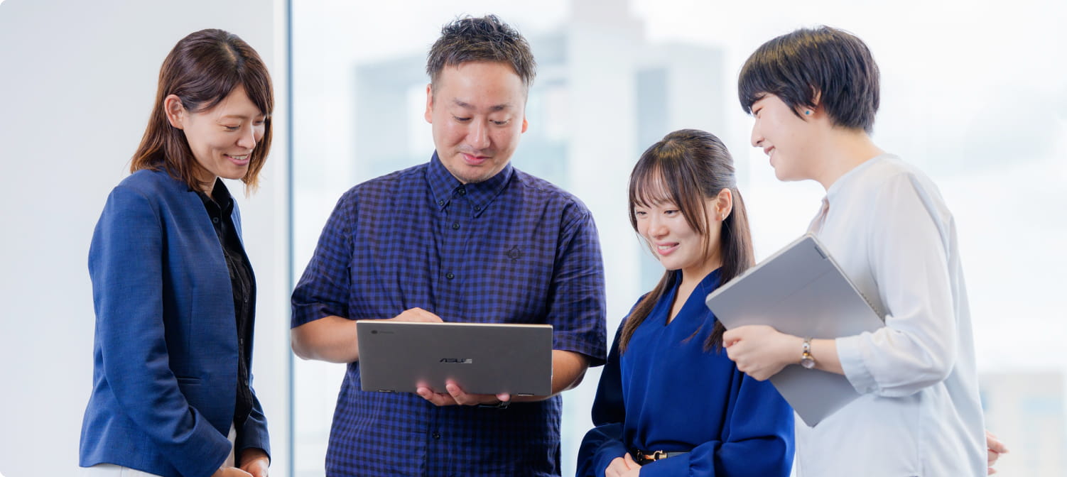4人の社員がコンピューターを操作している画像